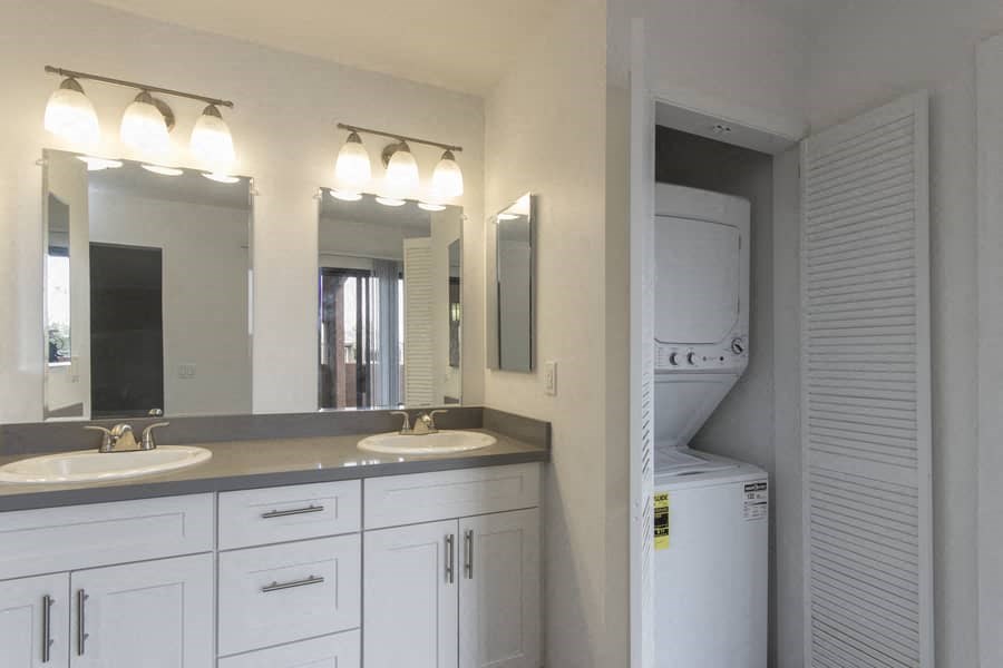 a bathroom with two sinks and a washer and dryer