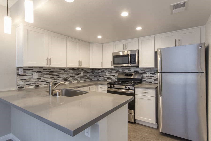 a kitchen with stainless steel appliances and white cabinets