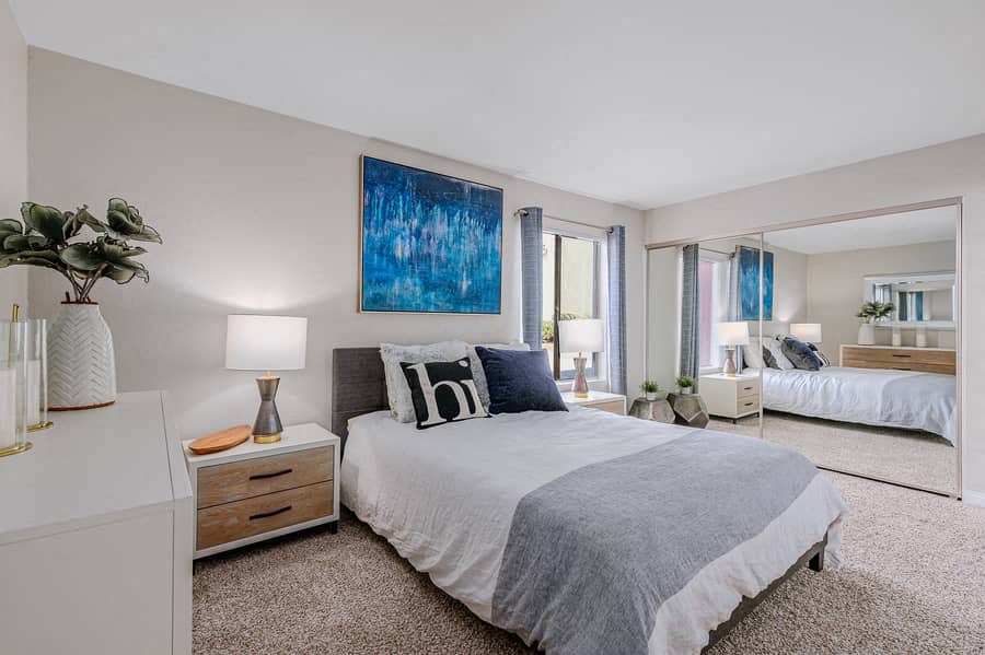 a bedroom with a bed and a large mirror