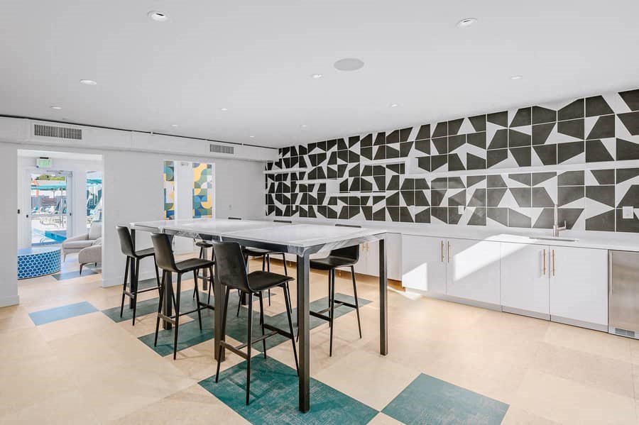a kitchen with a table and chairs and a geometric wall