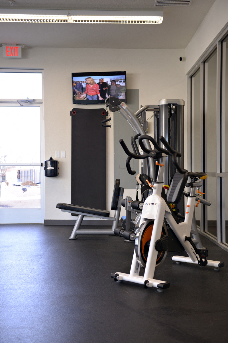 a spin bike in a gym with a tv on the wall