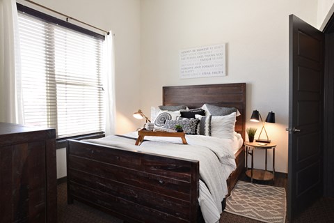 a bedroom with a bed and a dresser and a window