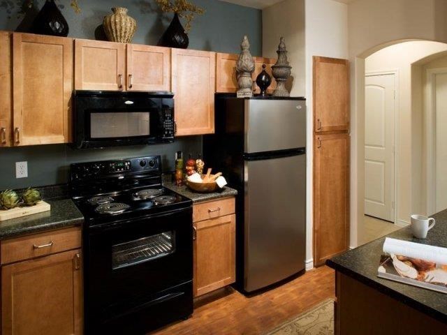 a kitchen with a black stove and a refrigerator