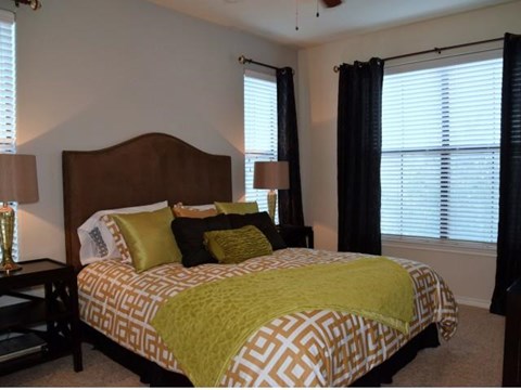 a bedroom with a bed and two windows