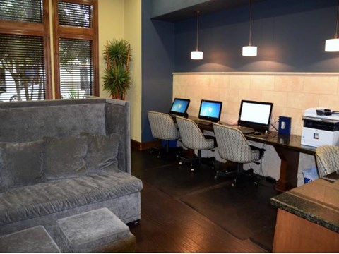 a room with a couch and a desk with computers