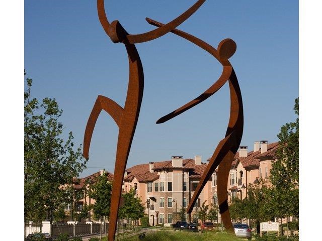a sculpture of two people in a park