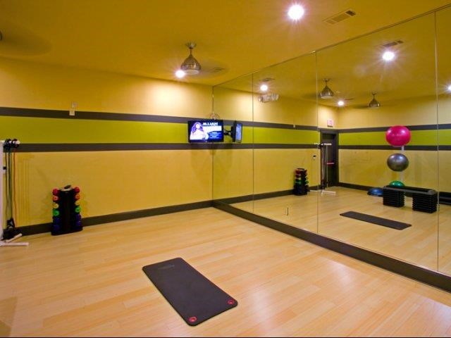 a yoga room with a mirror and a yoga mat