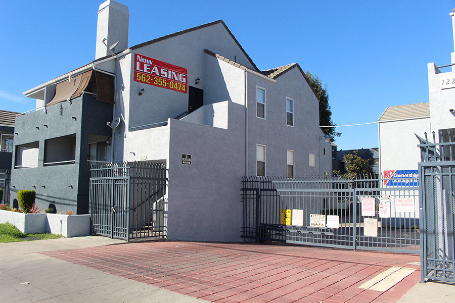 a house with a fence and a gate in front of it