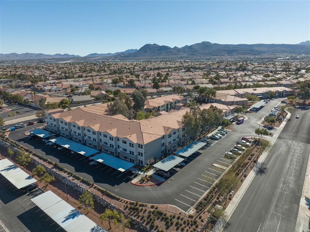 an aerial view of a building with a parking lot and a street