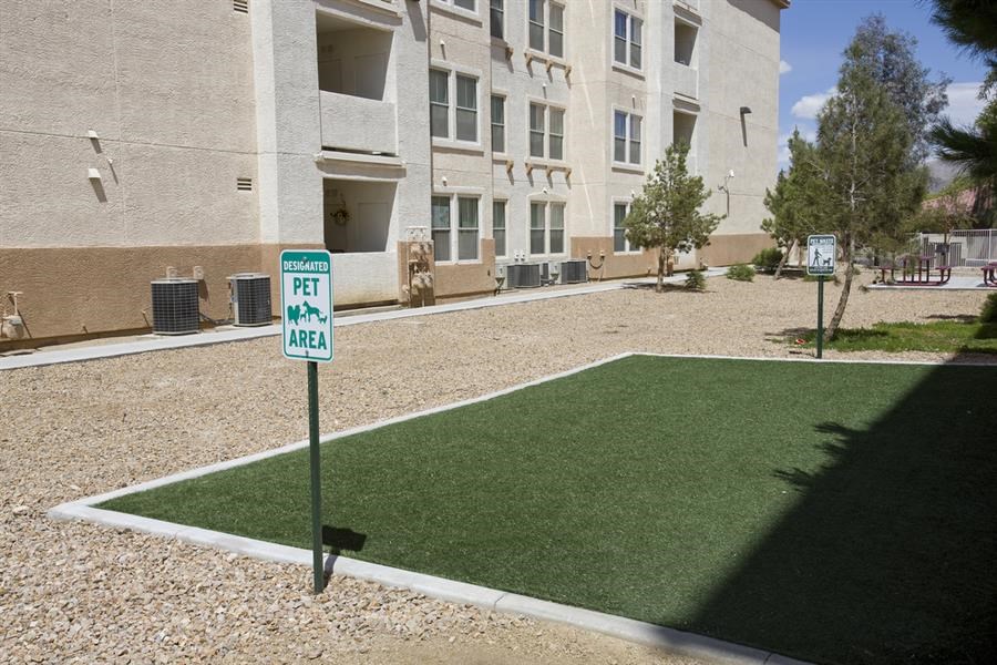 a green lawn in front of an apartment building