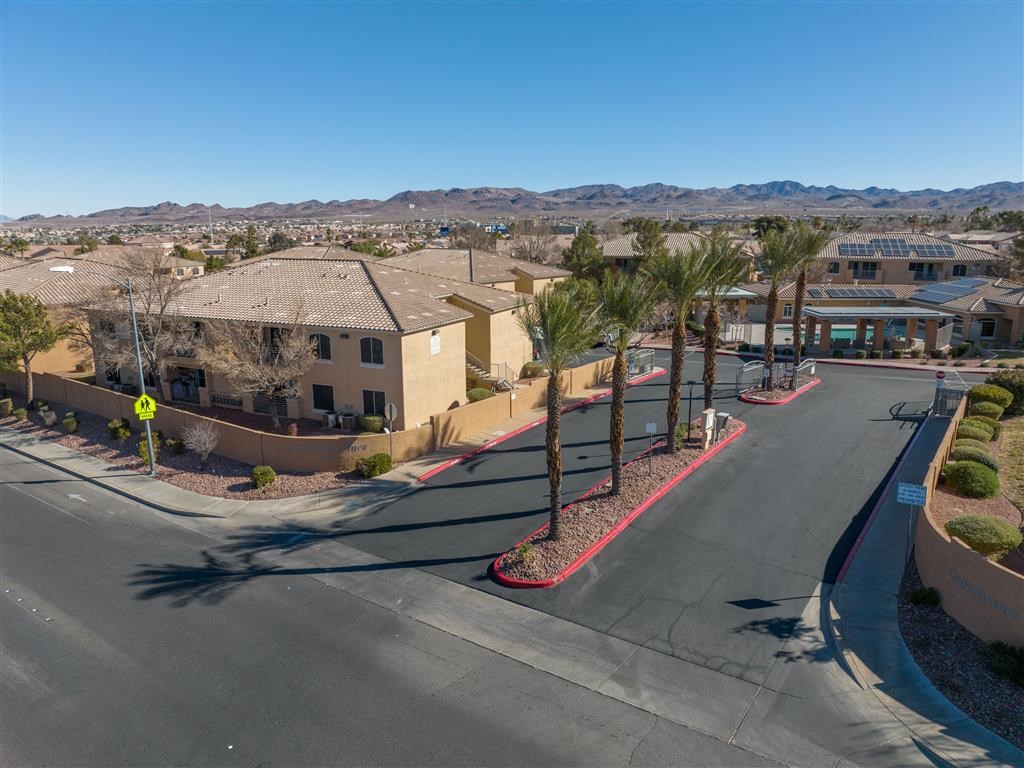 an aerial view of a street with houses and palm trees