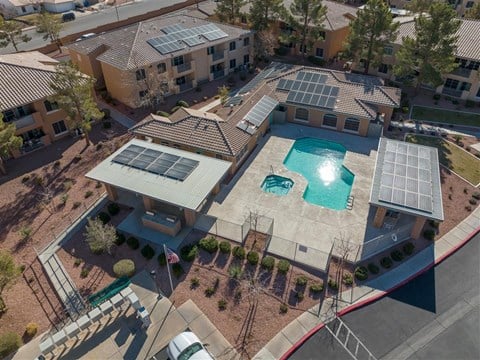 an aerial view of a building with a pool and solar panels