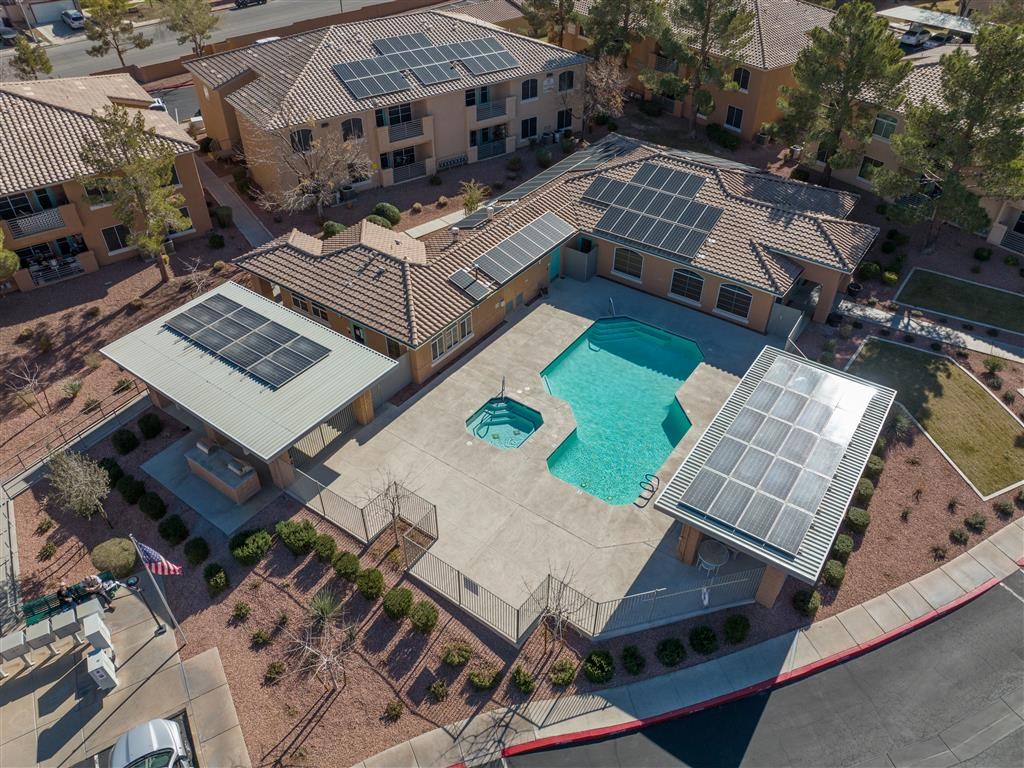 an aerial view of the pool area of a building with solar panels on the roof