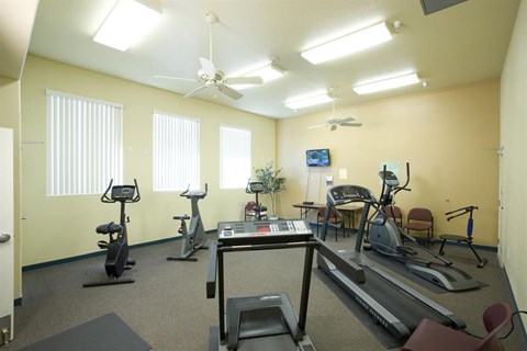 a gym with various exercise equipment in a room