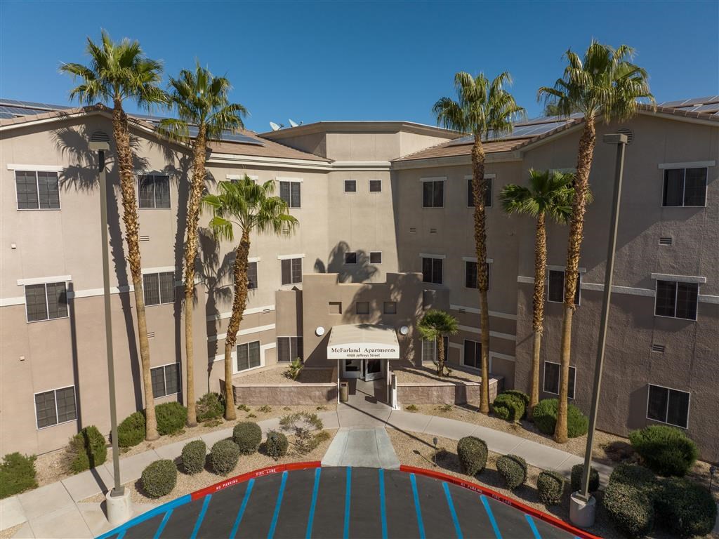 an exterior view of a building with palm trees