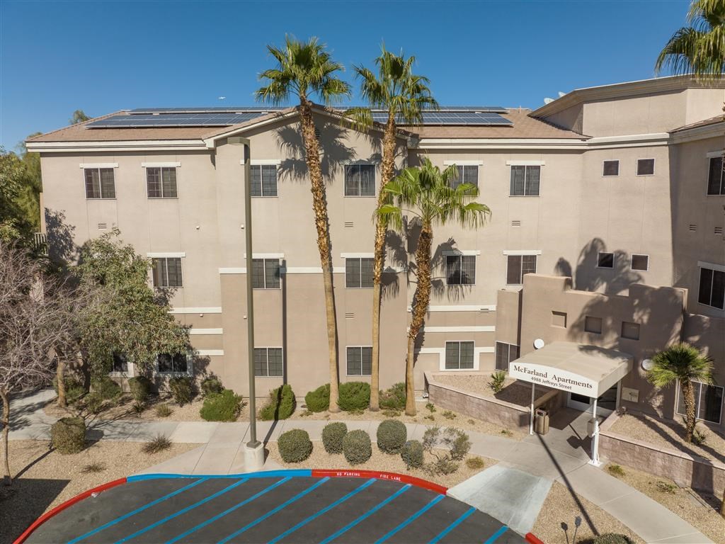 an overhead view of a building with palm trees and a basketball court
