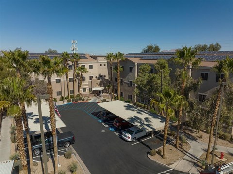 an aerial view of a parking lot with palm trees and buildings