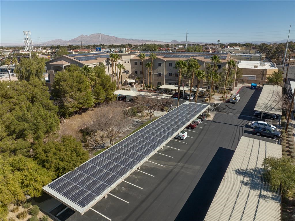 an aerial view of a parking lot with solar panels on the roof