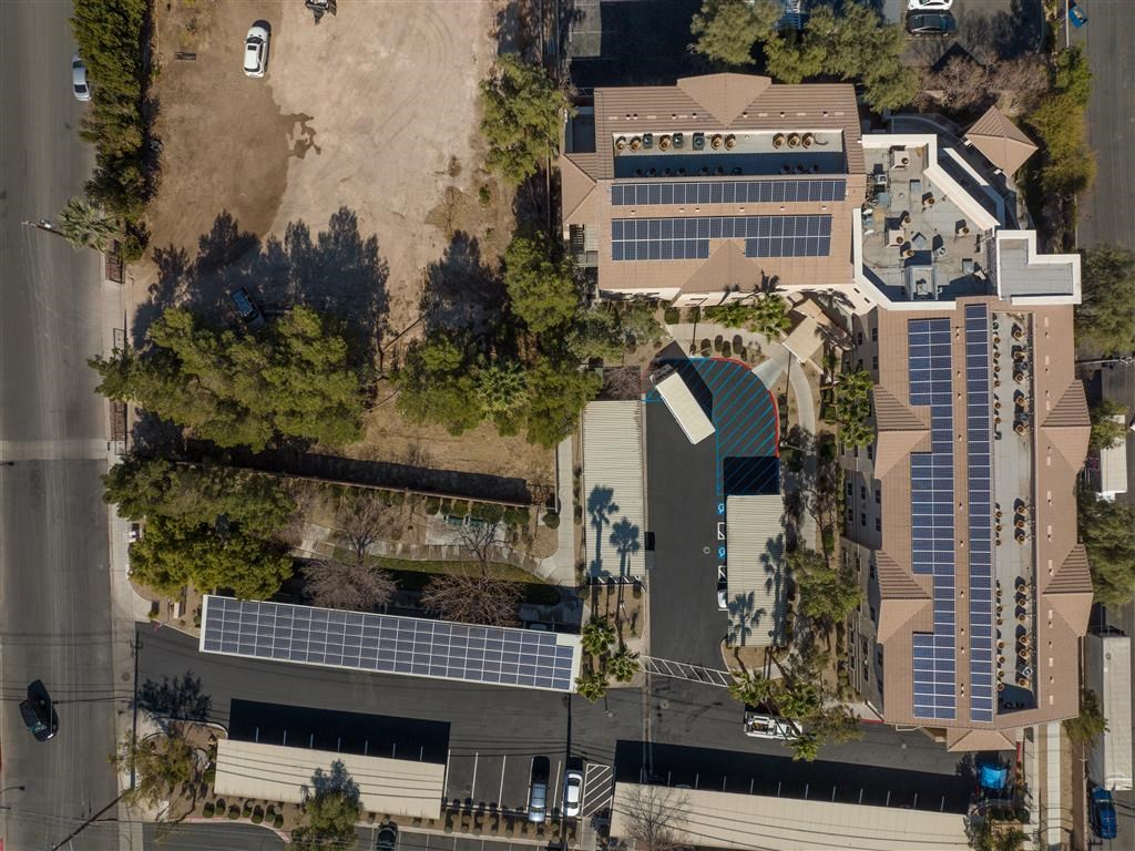 an aerial view of a building with solar panels on the roof