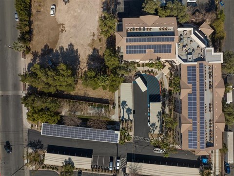 an aerial view of a building with solar panels on the roof