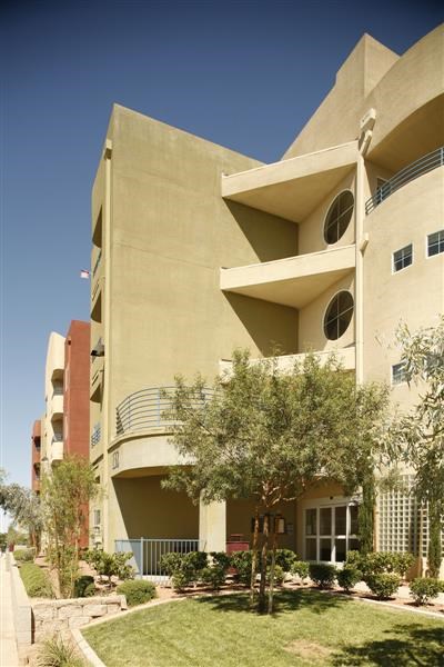 a large building with trees and grass in front of it