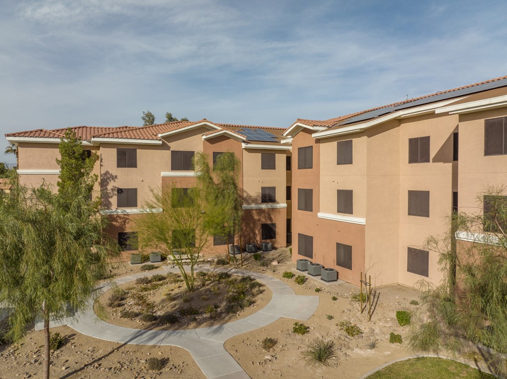 an exterior view of a building with a courtyard and trees