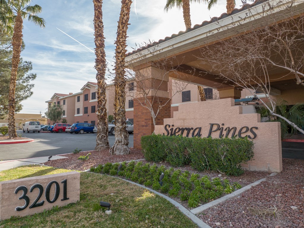 a building with a sign that says sierra pines with palm trees
