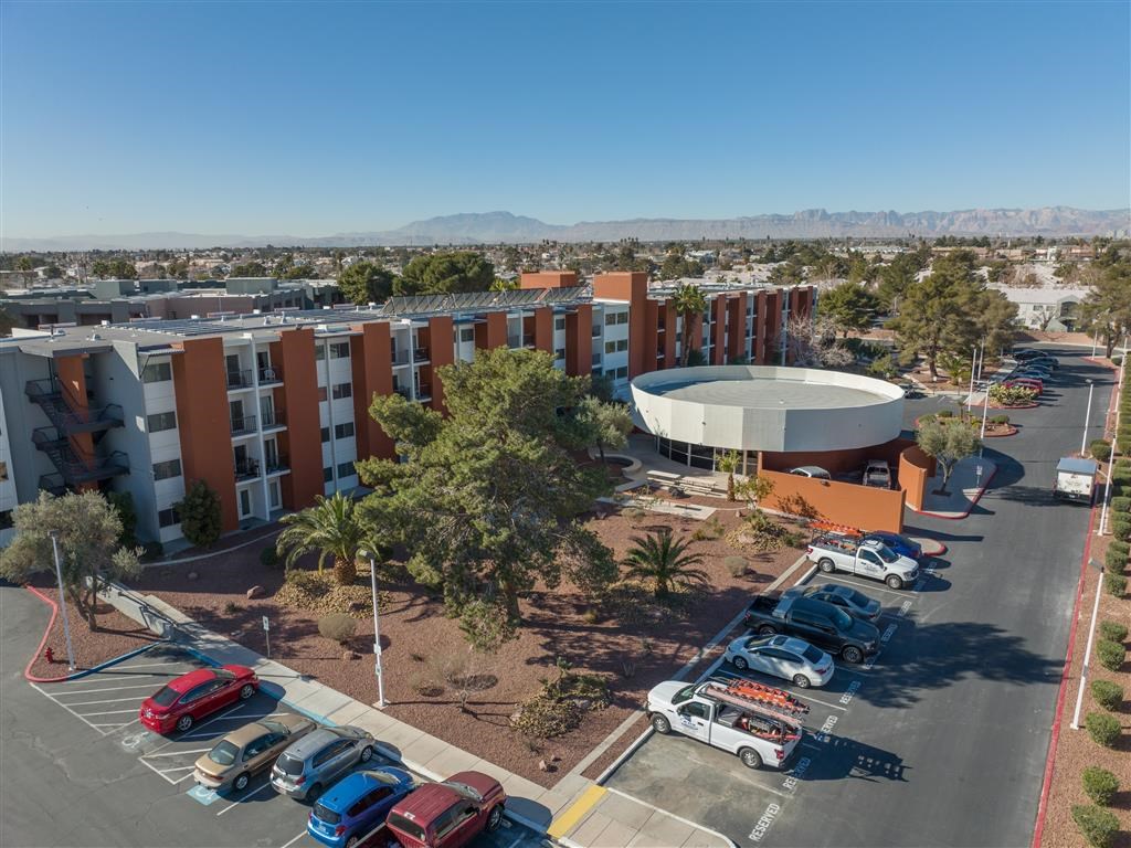 an aerial view of a parking lot with cars and a building