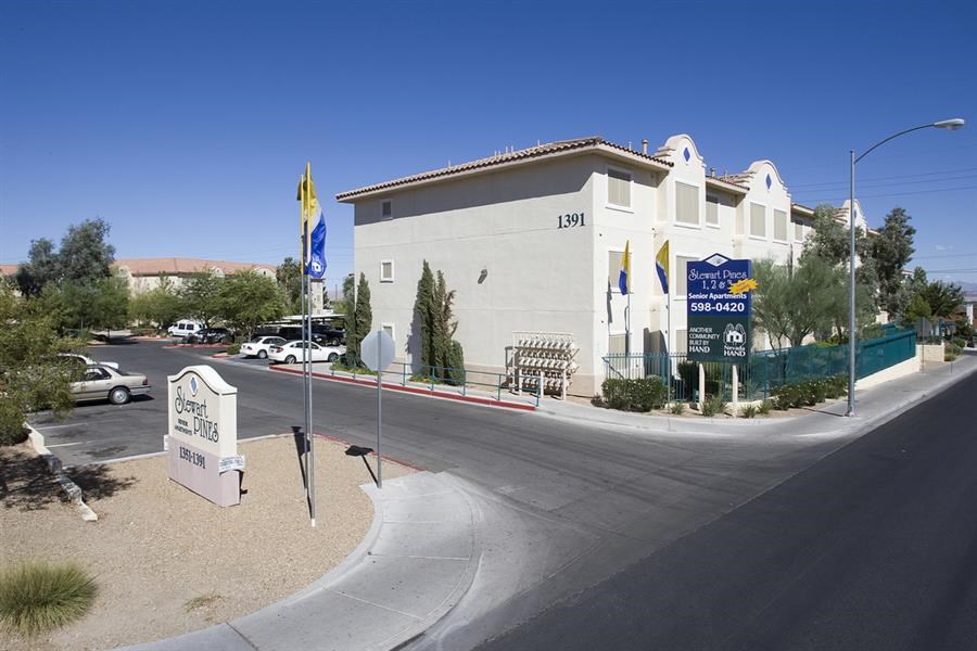 a white building with flags and a street in front of it