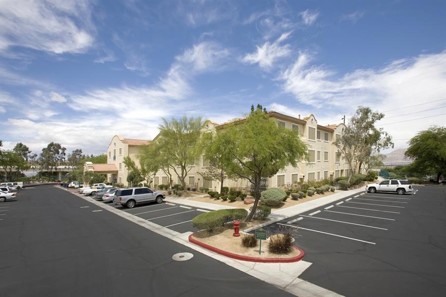 an empty parking lot with cars in front of a building