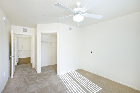 an empty living room with a ceiling fan