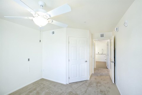 an empty room with a ceiling fan and a white door