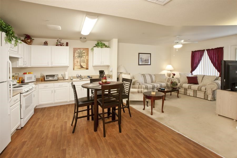 a kitchen and living room with a table and chairs