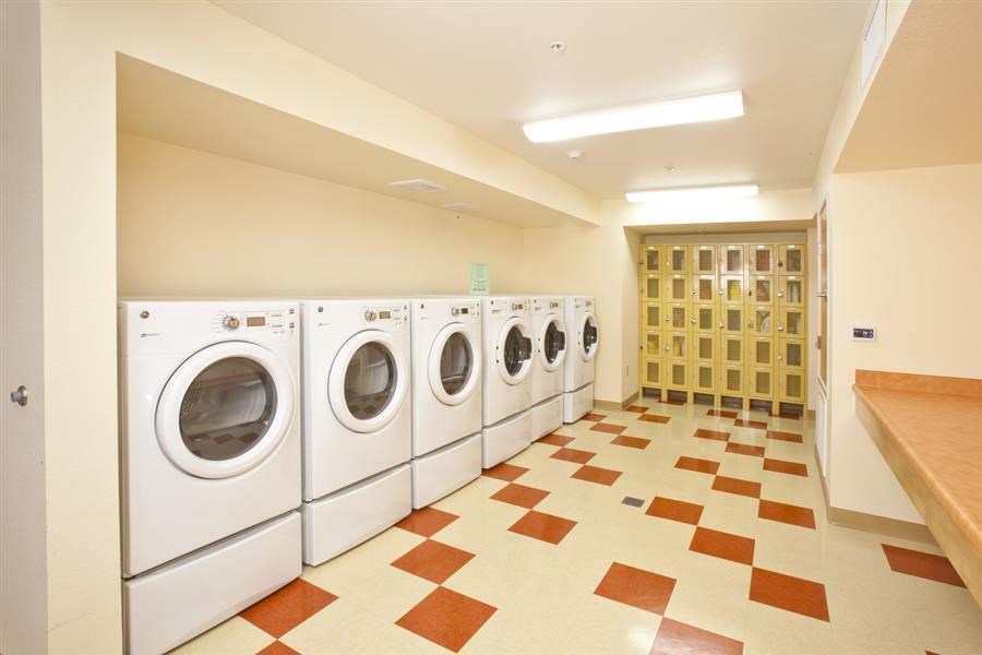 a laundry room with a row of washing machines in it