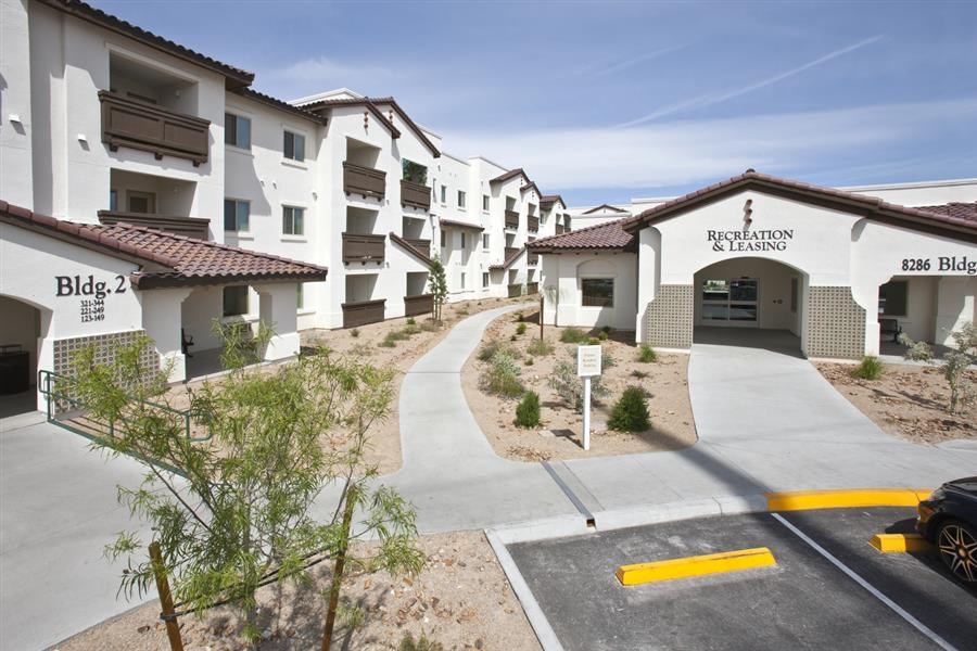 a row of white buildings with a road in front of them