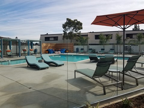 Outdoor pool area with lounge chairs at Mission Trails Apartments San Diego, California