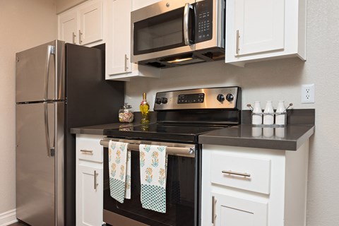 a kitchen with stainless steel appliances and white cabinets