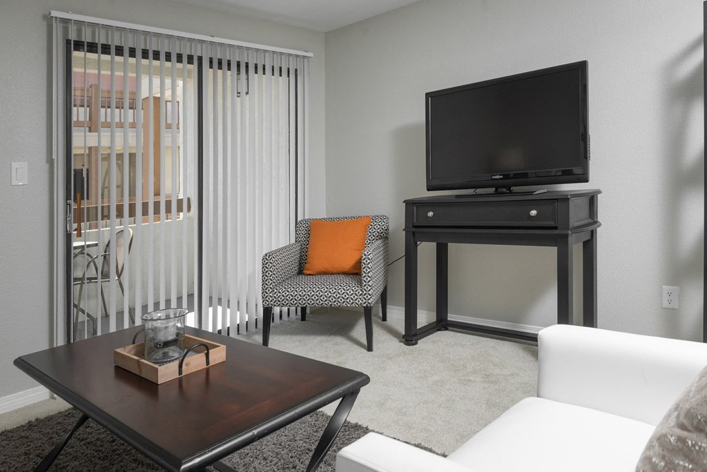 Living area with TV and sliding glass doors to balcony