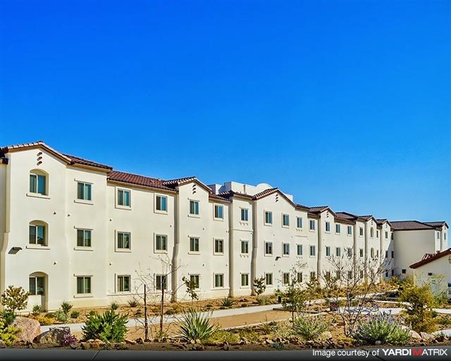 a row of apartment buildings in front of a blue sky
