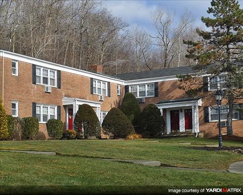 A brick house with a red door and white trim.