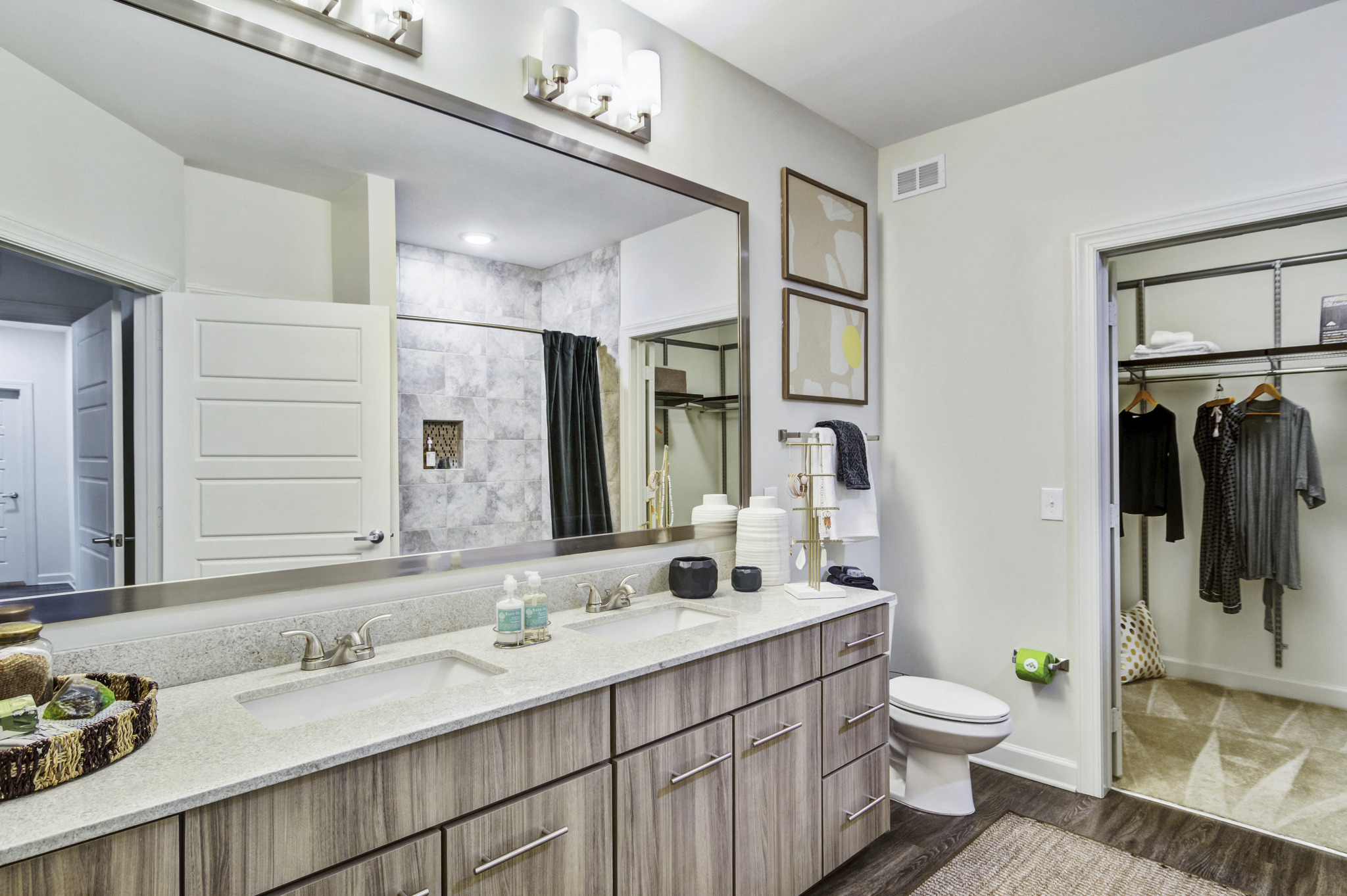 a bathroom with a large mirror and a sink and a toilet