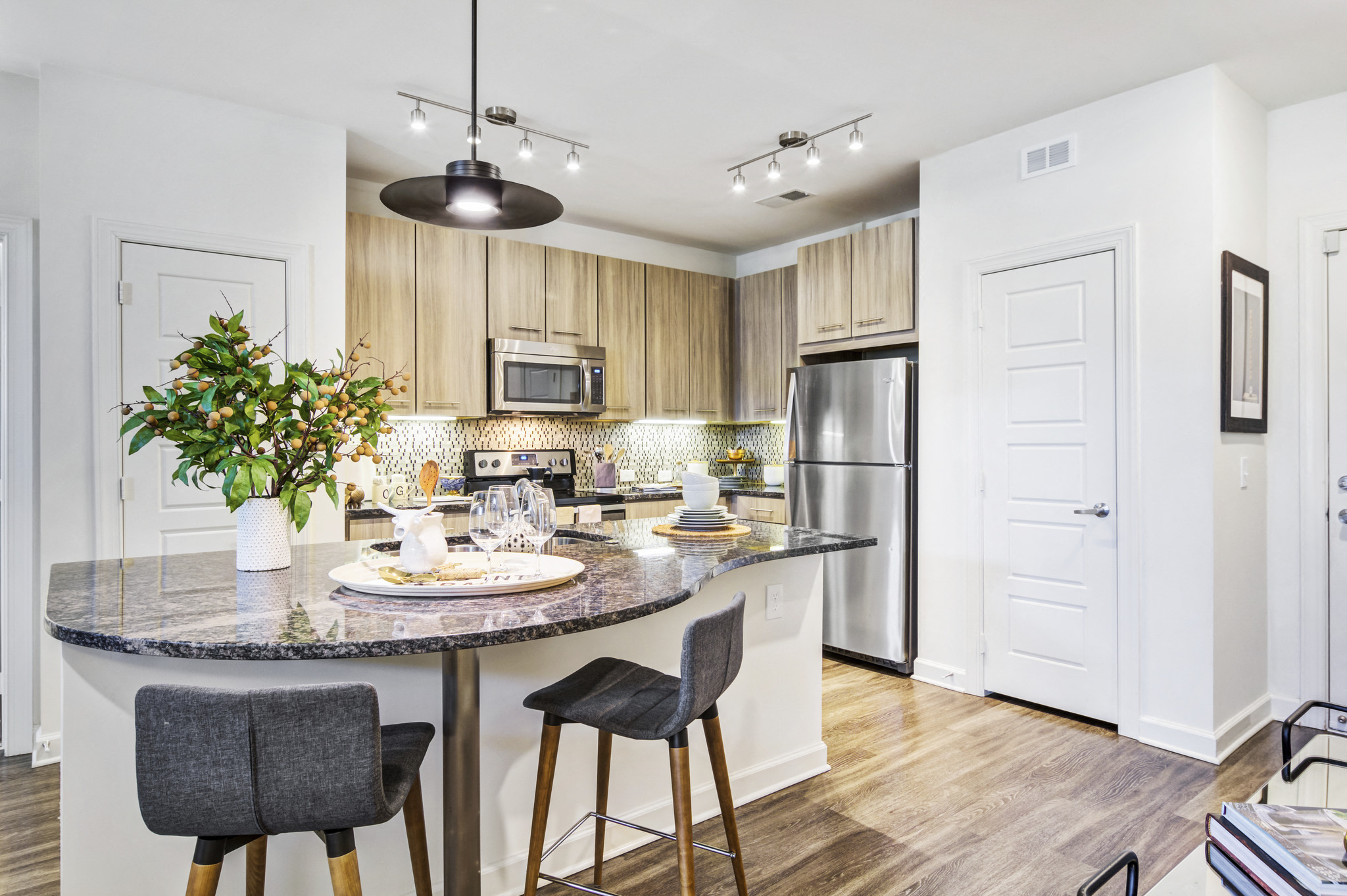 a kitchen with an island and a stainless steel refrigerator
