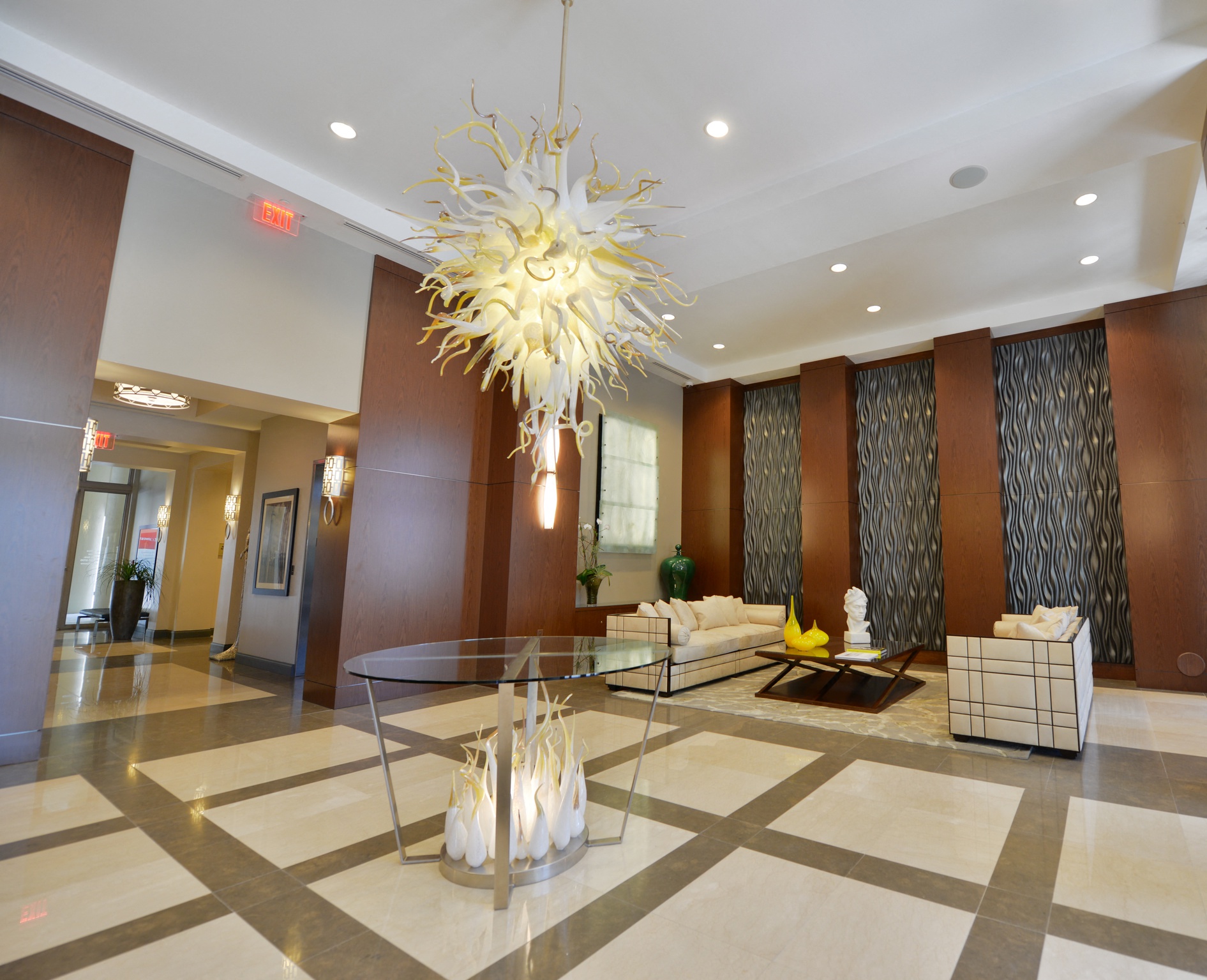 a lobby with a glass table and a chandelier