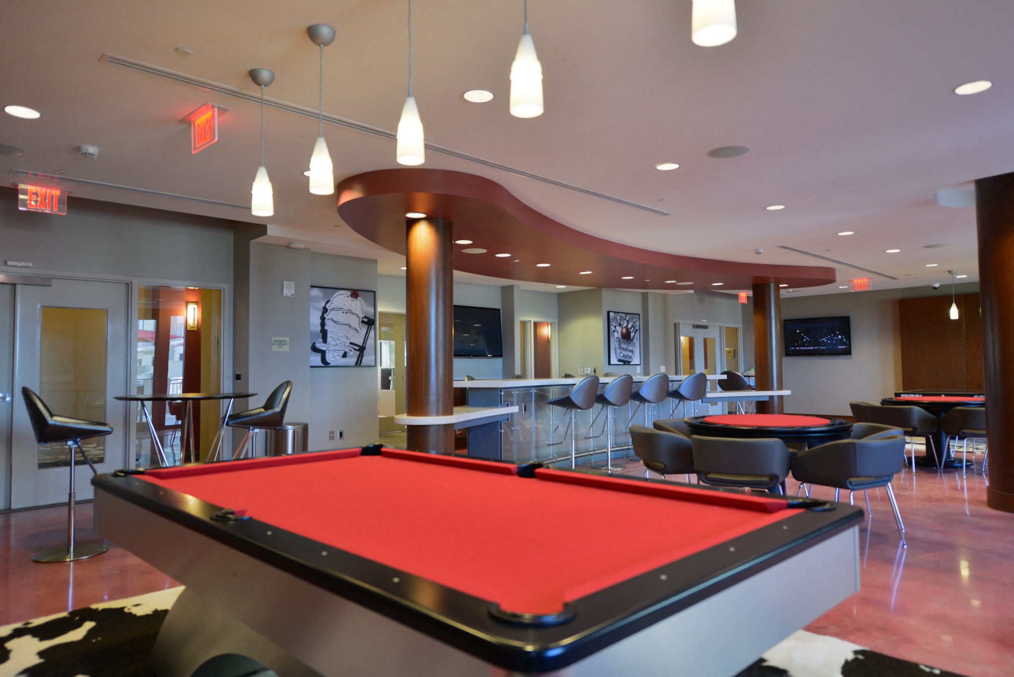 a red pool table in a room with tables and chairs