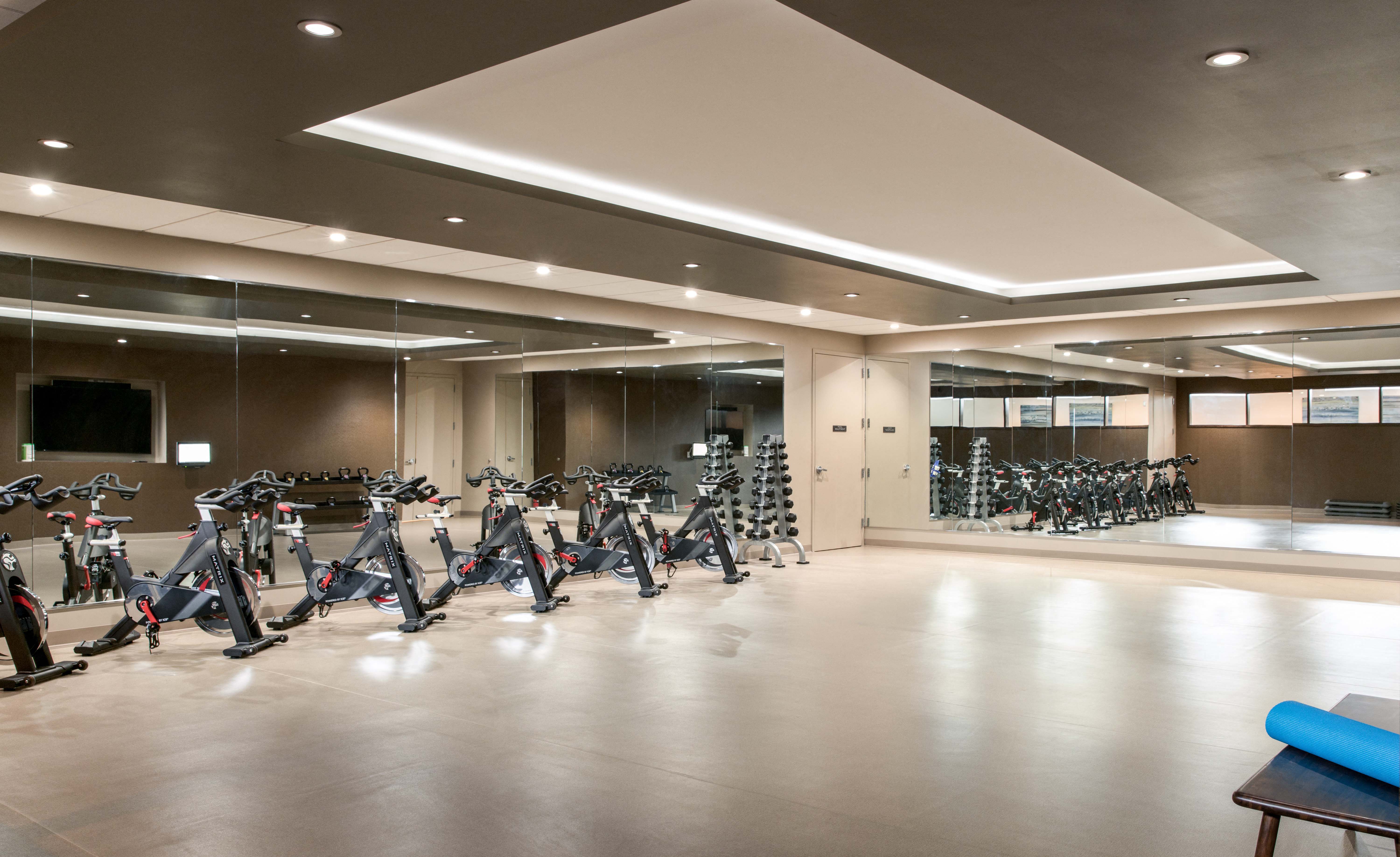 a fitness room with many exercise bikes in it
