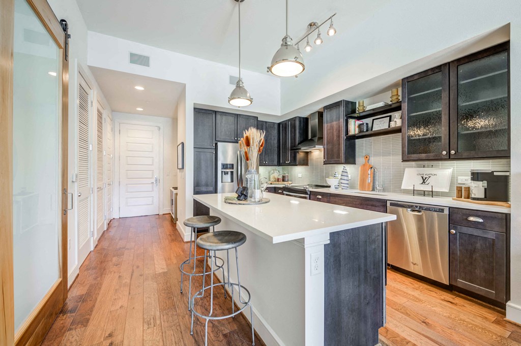 a kitchen with a white counter top and dark cabinets