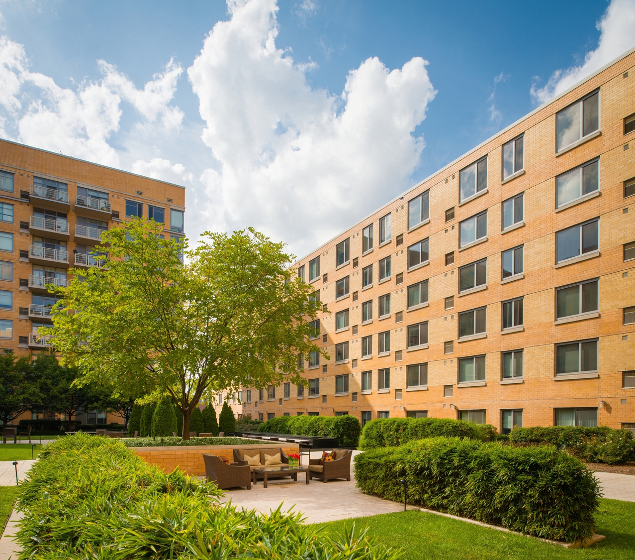 a courtyard with a table and chairs in front of an apartment building