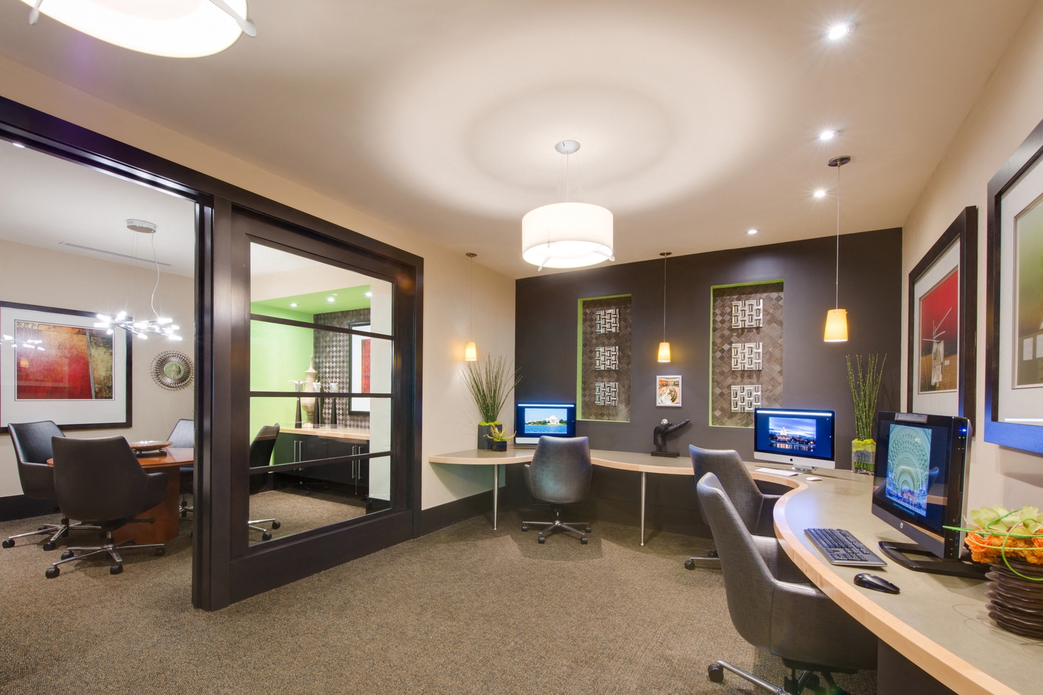 an office with desks and chairs and computer monitors