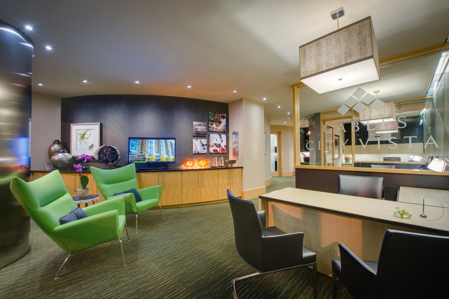 a lobby of a hotel with green chairs and a reception desk