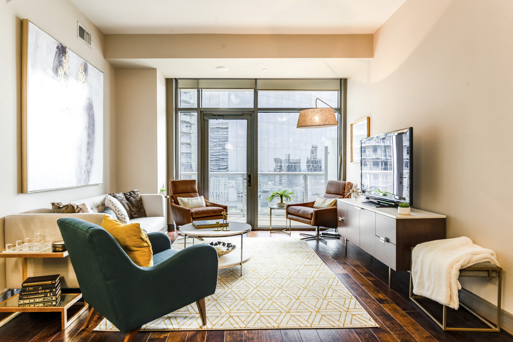 a living room with a couch and chairs and a large window